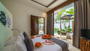 Habitación de hotel con cama, televisión y vistas al exterior.