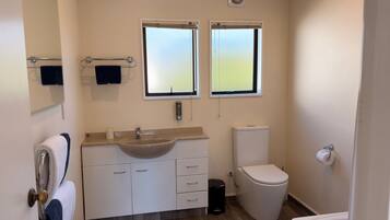 A bathroom with a sink, toilet, and a towel rack.