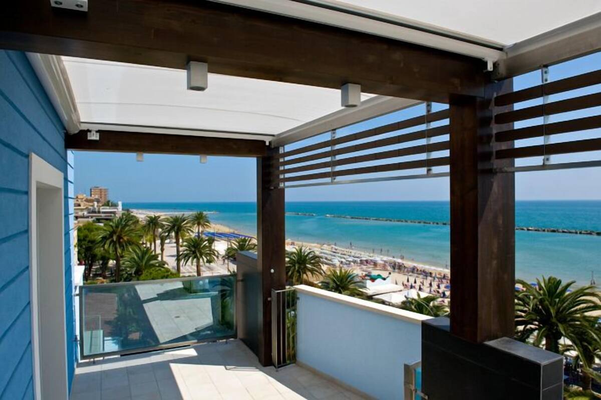 Un balcón con vista a la playa y al muelle.