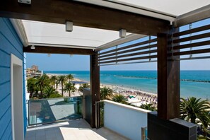 Un balcón con vista a la playa y al muelle.