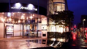 Una entrada de hotel moderna con fachada de vidrio y un cartel que dice "HOTEL AHEADONE".