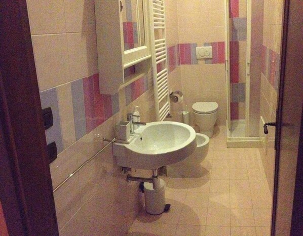 Un baño con lavamanos, inodoro y ducha.