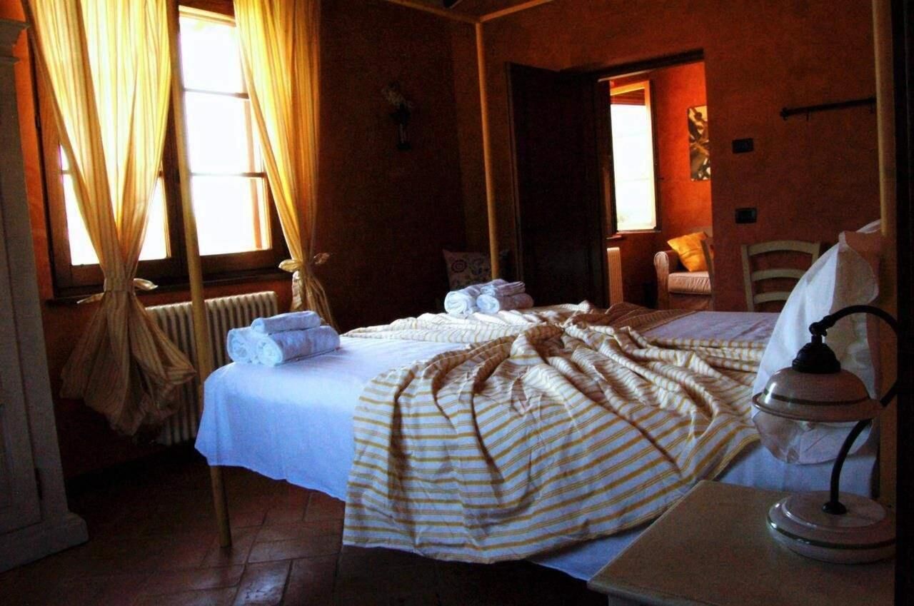 Een kamer met twee bedden, een radiator, een lamp en gordijnen.