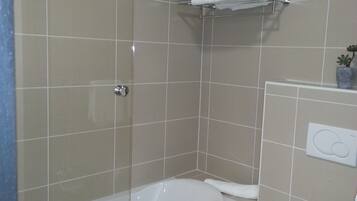 A bathroom with a bathtub, toilet, and a towel rack.