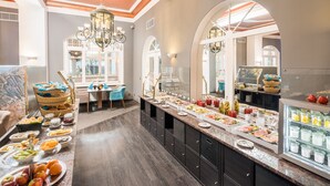 A buffet with various food items and a seating area with chairs and a table. - Hotel Residenz Waldkrone (Kuehlungsborn)