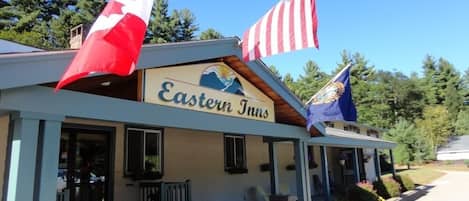 A building with a sign reading "Eastern Inns" and flags of Canada and the United States.