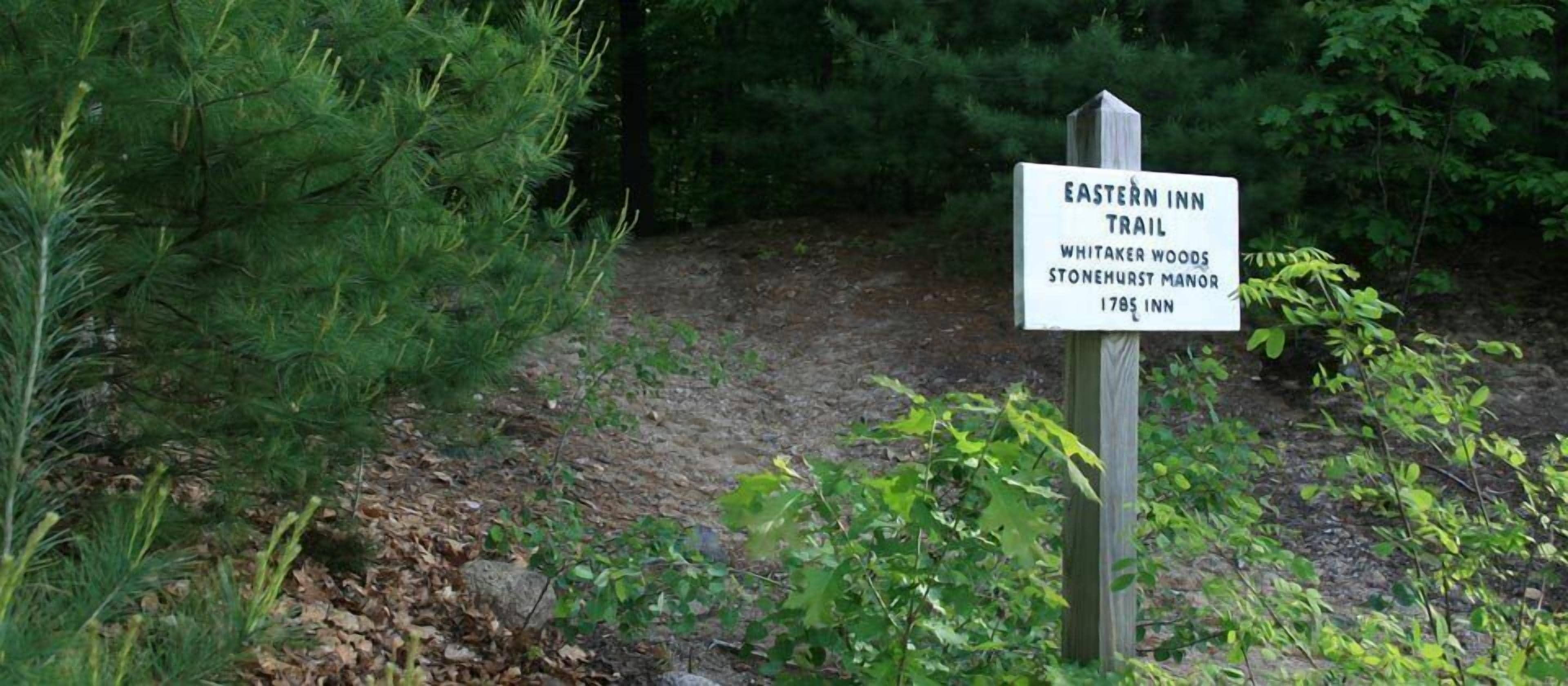 Un panneau indiquant le début du sentier Eastern Inn Trail, situé dans les bois de Whitaker, près du manoir de Stonehurst, et datant de 1785.