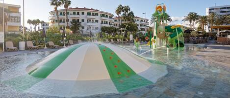 A water play area with a colorful slide and a pool.