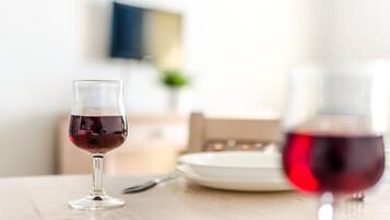 Een eettafel met een glas rode wijn en een bord.