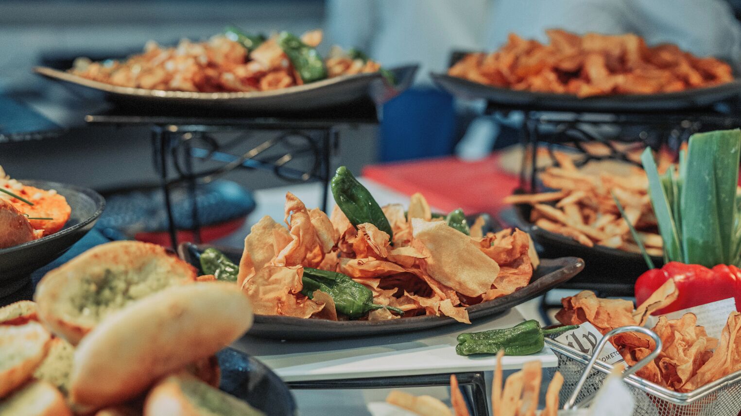 Ein Buffet mit verschiedenen Speisen, darunter Brot, Chips und Gemüse.