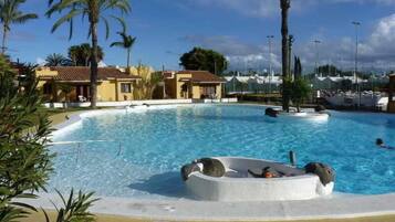 Een buitenzwembad, parasols voor strand/zwembad