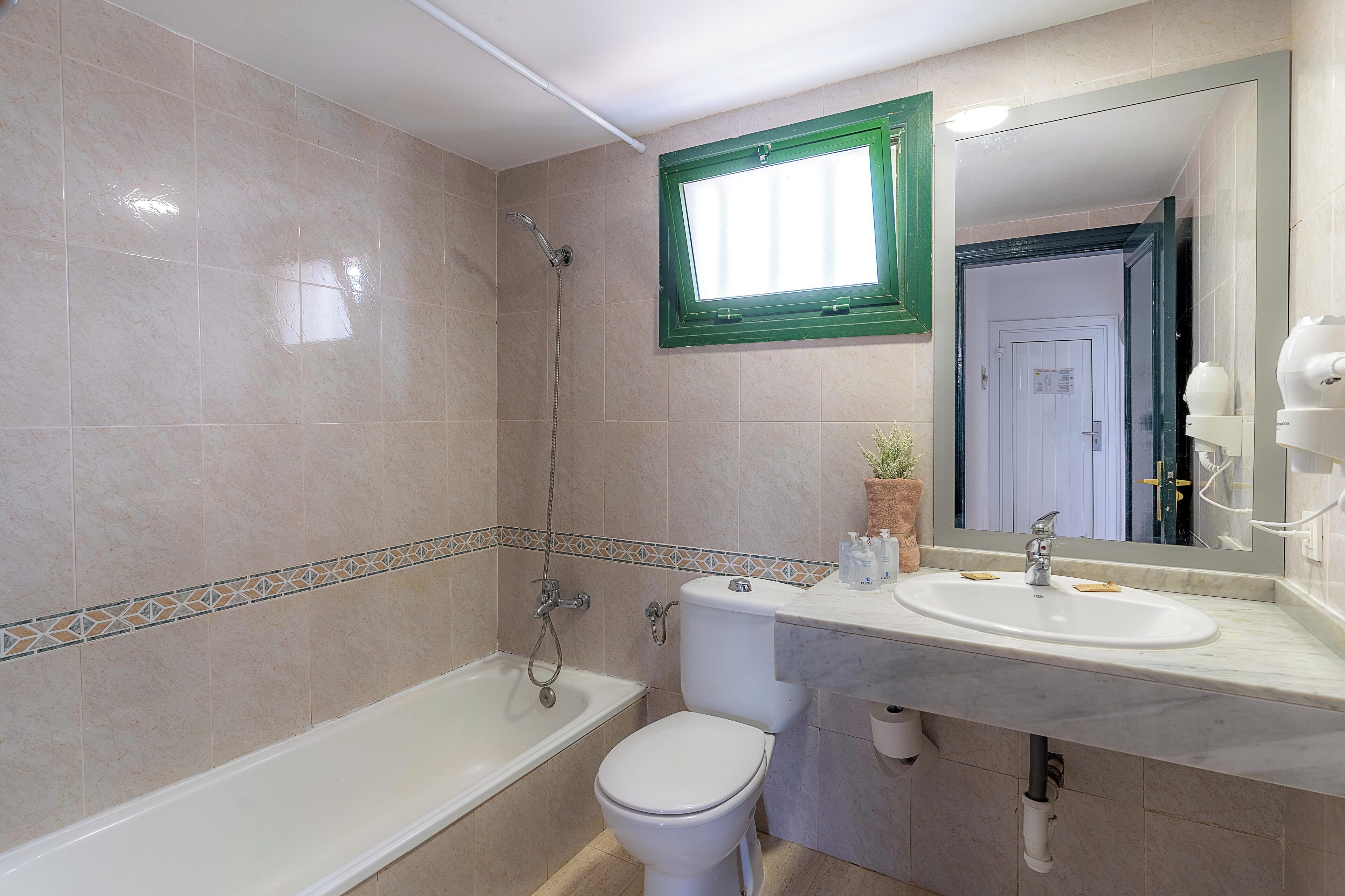 A bathroom with a bathtub, toilet, and sink.