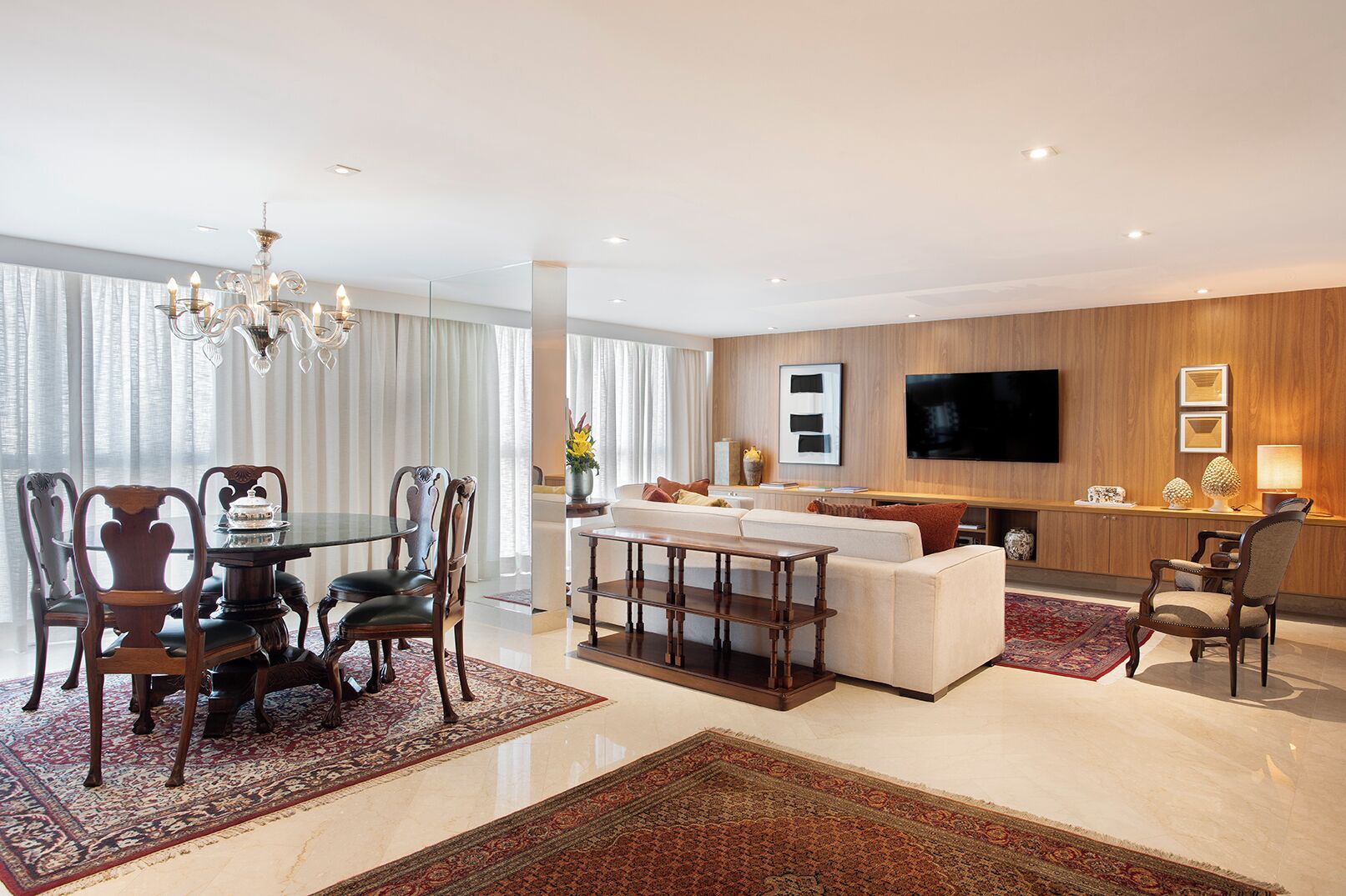 A modern living room with a dining area, a sofa, a TV, and a chandelier.