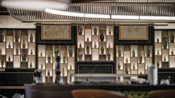 L’intérieur d’un restaurant présente une décoration asiatique traditionnelle, avec une variété de vases en céramique et d’œuvres d’art exposées sur des étagères.