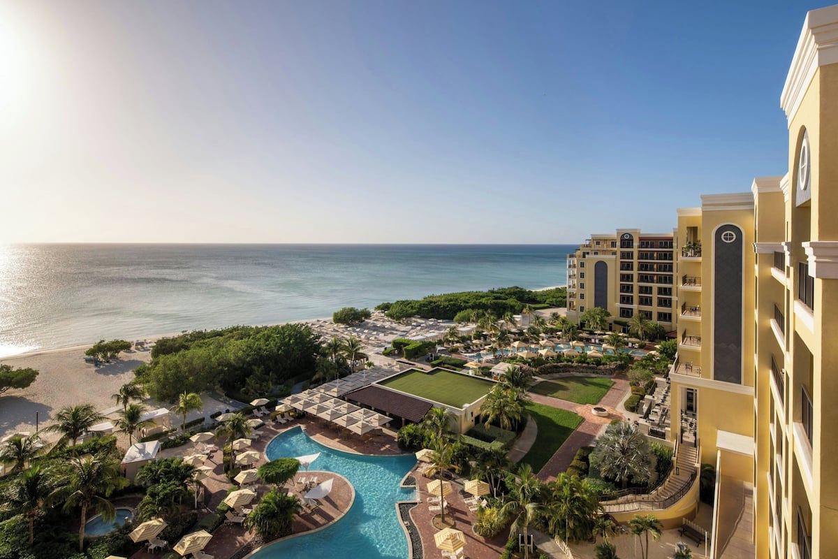 Un resort con piscina, playa y vista al océano.