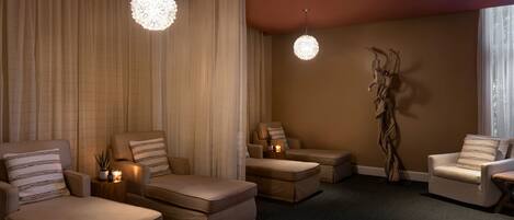 A spacious room with a large window, a ceiling light fixture, and a wall-mounted sculpture.