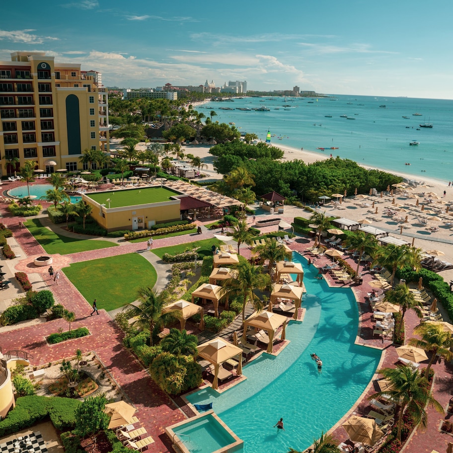 A resort with a large pool, beach, and multiple buildings.