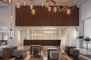 A modern lobby with a reception desk, seating area, and decorative lighting.