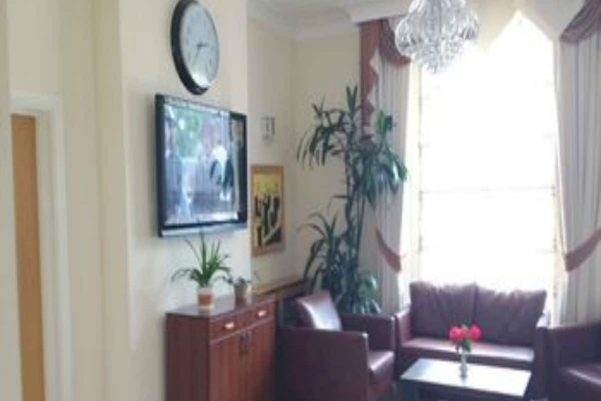 Eenpersoonskamer, en-suite badkamer | Een kluis op de kamer, een bureau, een strijkplank/strijkijzer