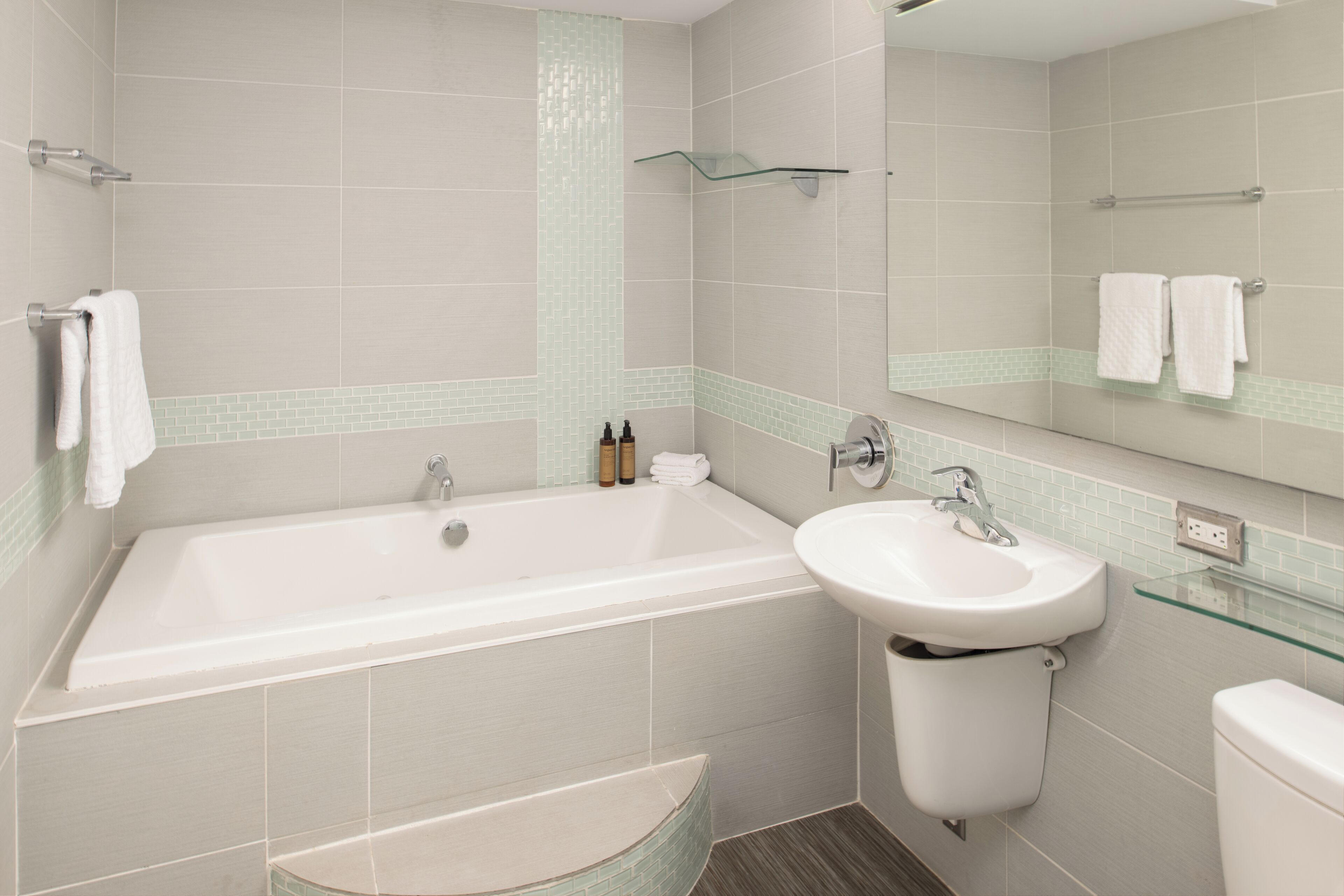 A modern bathroom with a bathtub, sink, and toilet.