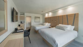 Quarto de hotel moderno com duas camas, uma escrivaninha e uma cadeira.