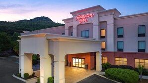 Ein Hampton Inn Hotel mit moderner Fassade, überdachter Einfahrt und Parkplatz.