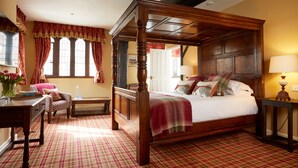 A four-poster bed with a checkered floor, a desk with a chair, and a lamp on a side table. - Burford House (Burford)