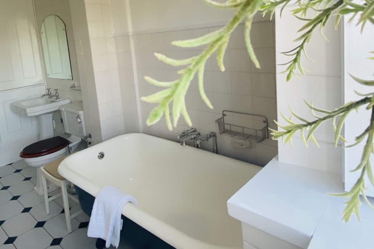 A bathroom with a bathtub, a toilet, a sink, and a mirror.
