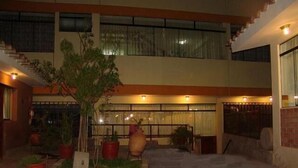 A courtyard with a central garden, potted plants, and a seating area. - Inkayra Hotel (Cusco)