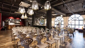 A modern restaurant with unique chairs, a bar area, and large windows.