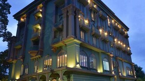 Un edificio grande de varios pisos con estilo arquitectónico clásico, con muchas ventanas y balcones.