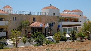 A hotel with a stone facade, multiple balconies, and a tiled roof. - Moniatis Hotel (Limassol)