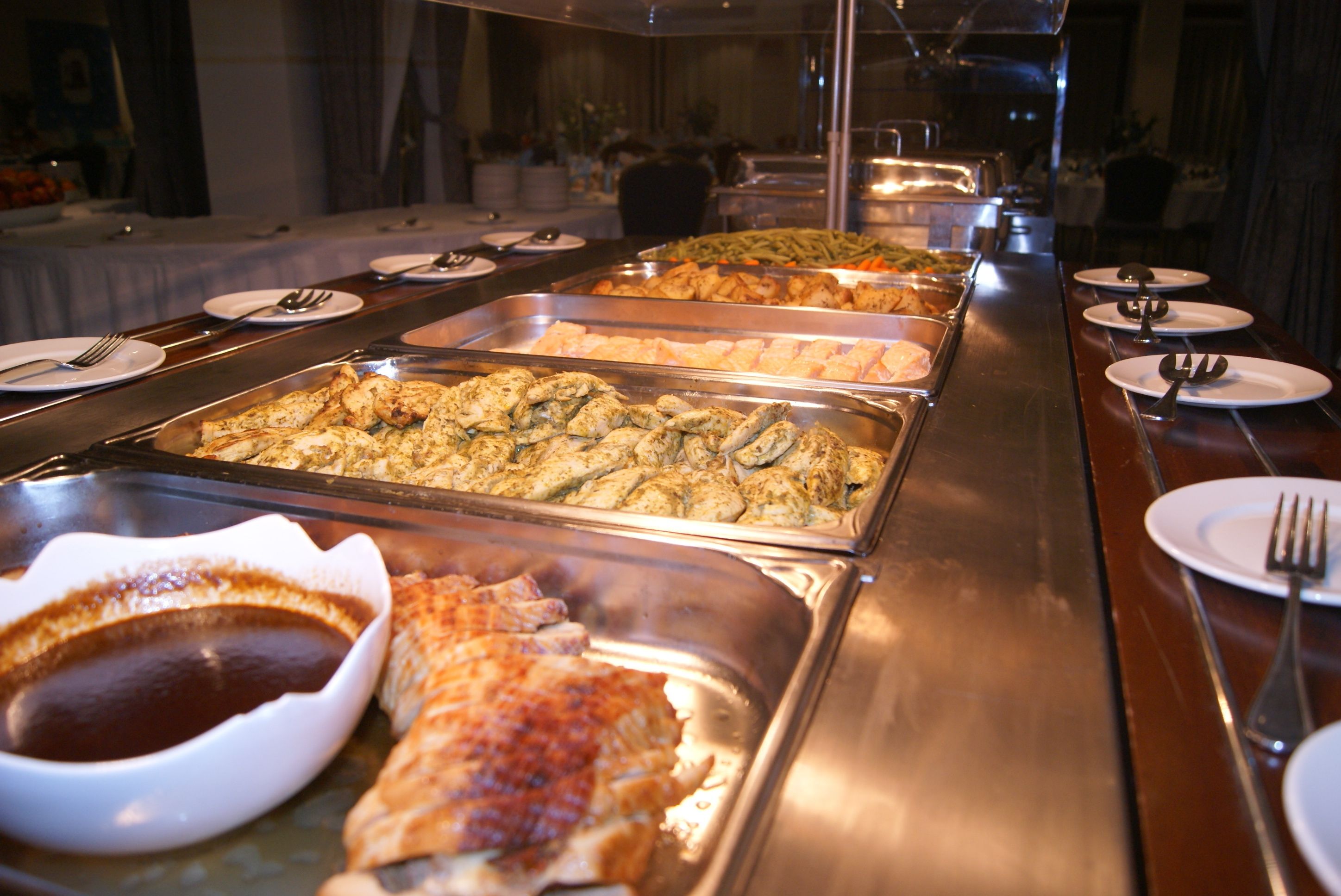 A buffet with various dishes and condiments.
