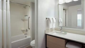 A bathroom with a bathtub, toilet, sink, and a mirror.