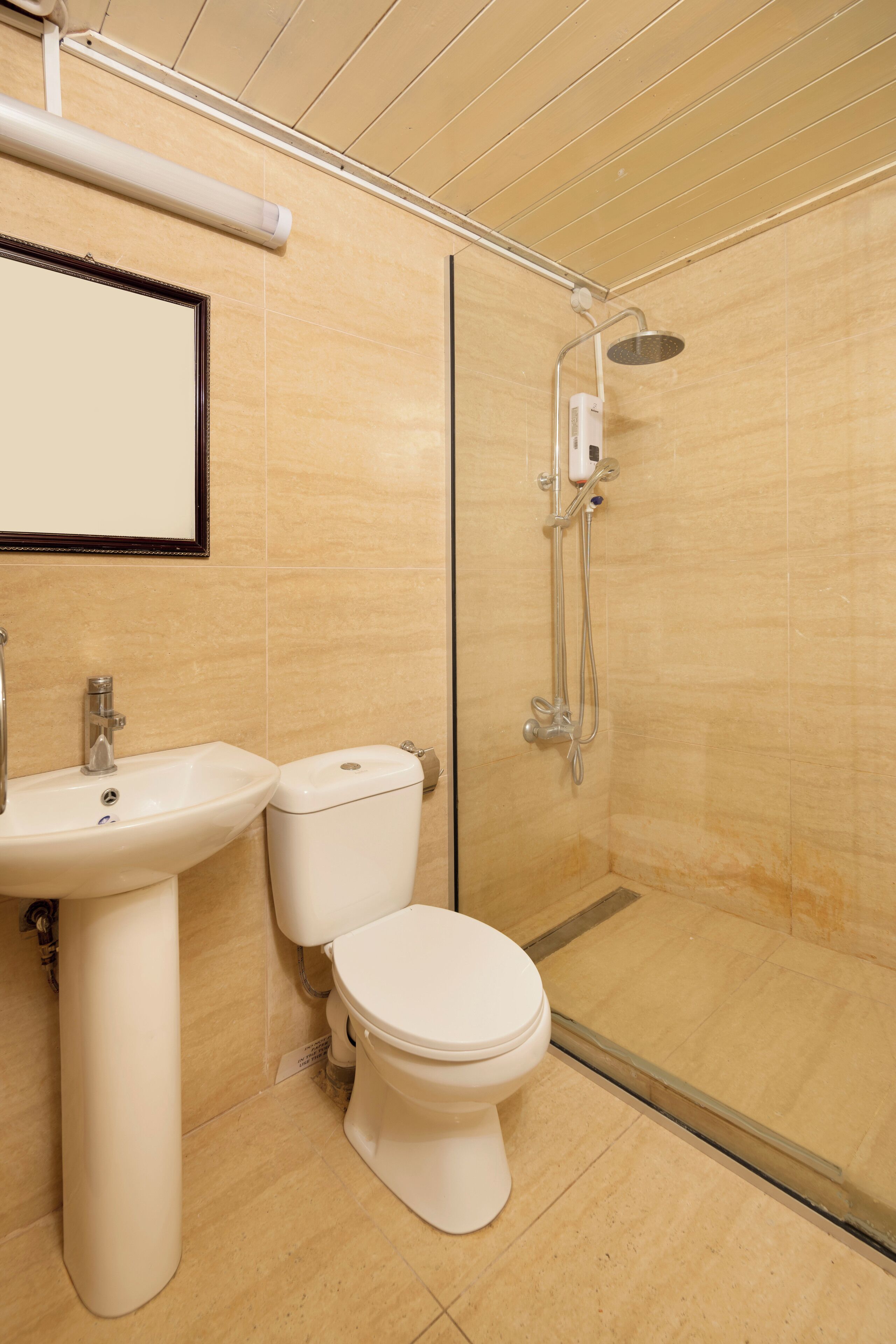 Baño con lavamanos, inodoro y ducha de vidrio.