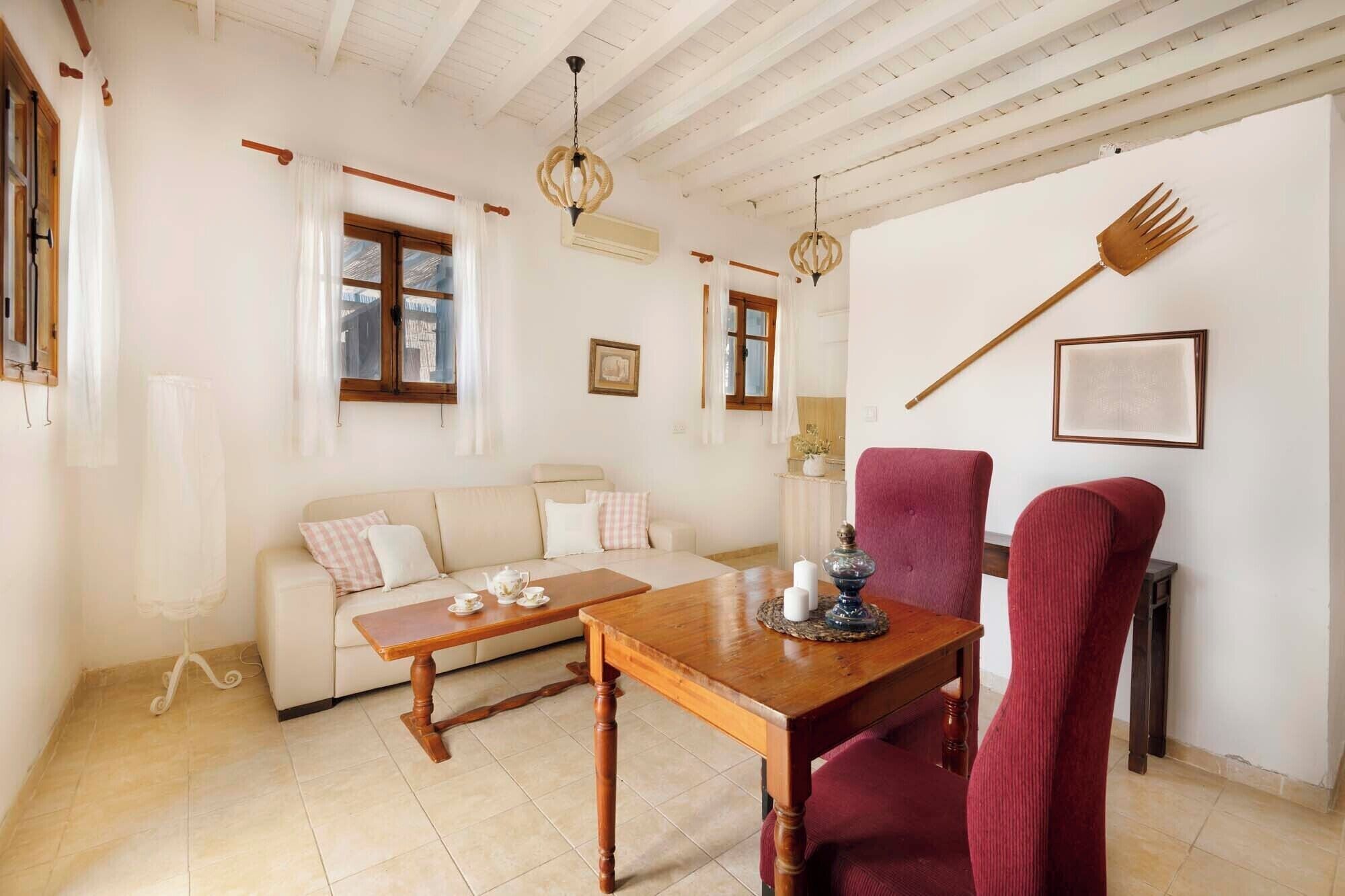 A cozy room with a wooden dining table, a sofa, and a red chair.