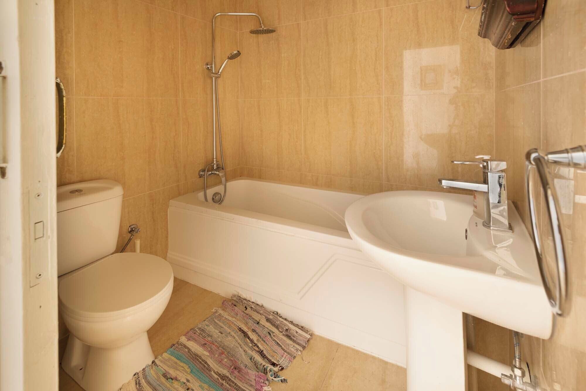 A bathroom with a toilet, a bathtub, and a sink.