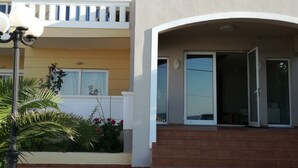 Un hotel llamado "Mariamathi Apartments" con un diseño moderno, que cuenta con un balcón y una zona de entrada con baldosas.