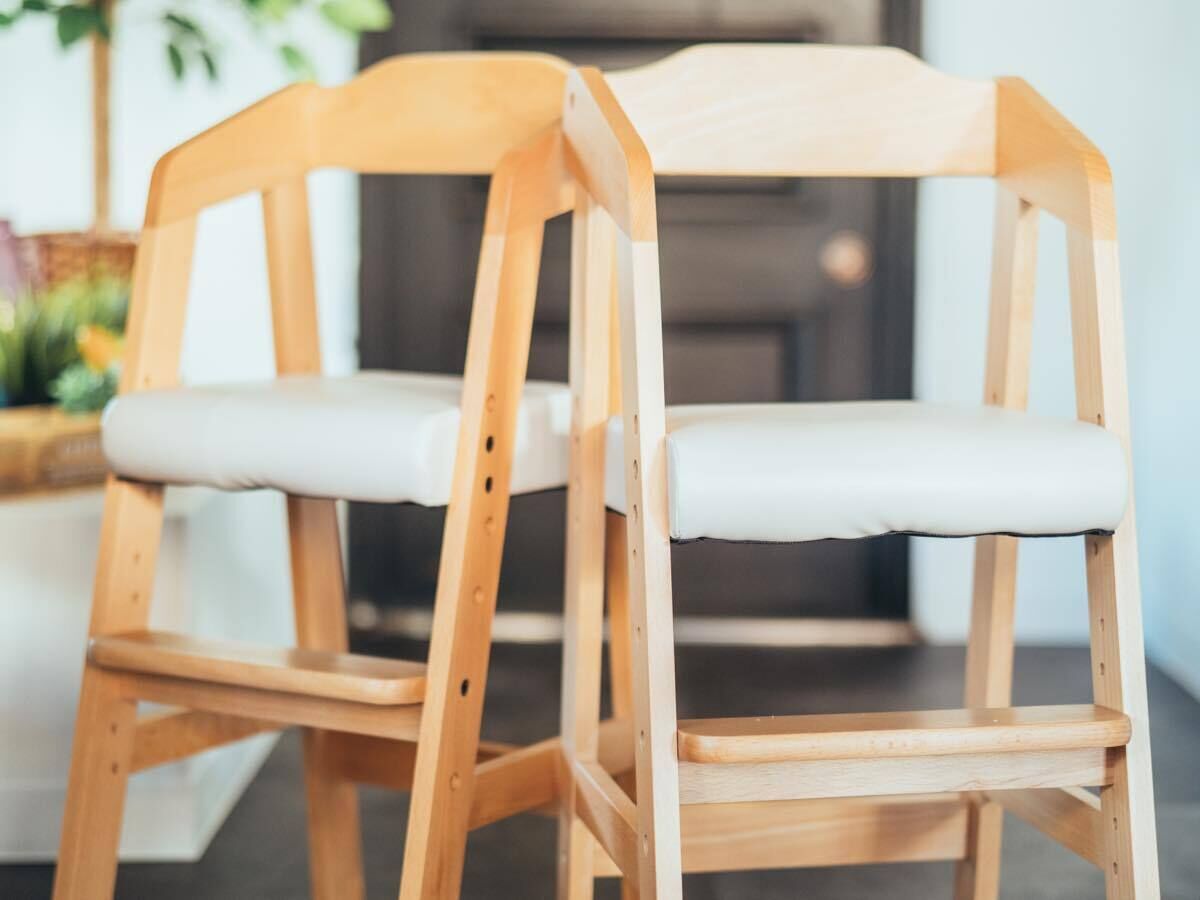 Una silla de madera con un cojín blanco y estructura de madera.
