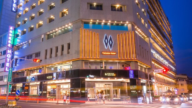 Un hotel moderno a più piani, con finestre illuminate e un logo ben visibile sulla facciata.