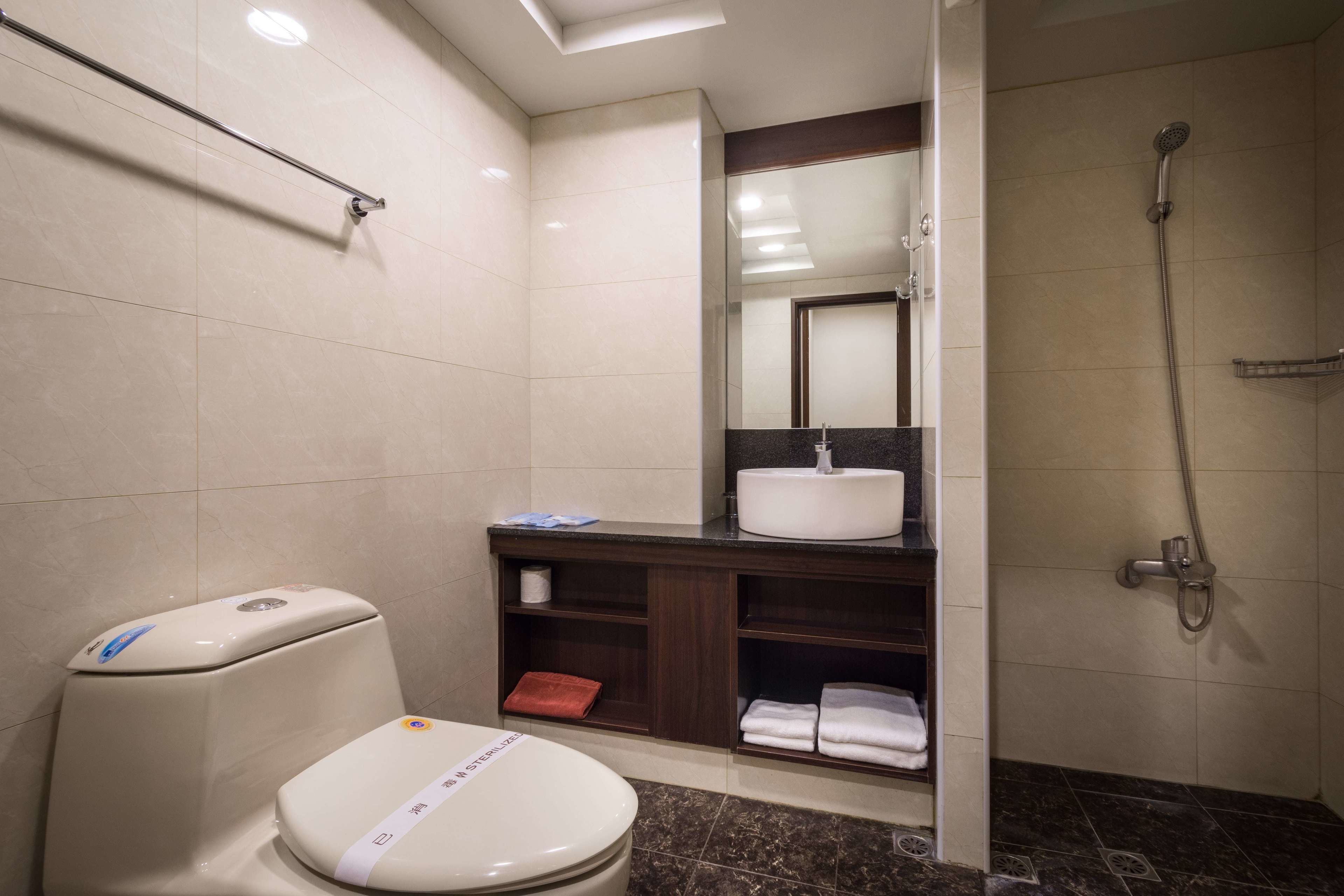 Un baño moderno con inodoro, lavamanos y ducha.