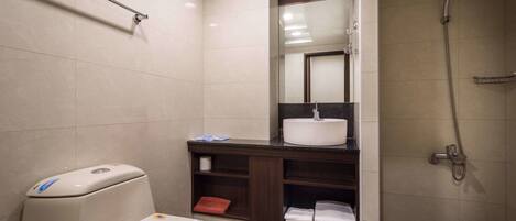 Un baño moderno con inodoro, lavamanos y ducha.