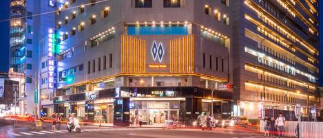 A multi-story hotel with a prominent sign for the "Hotel" and "Teplos Hotel" on the ground floor.