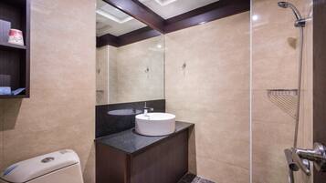 A modern bathroom with a round sink, a shower, and a toilet.
