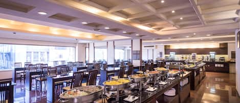 A buffet area with multiple serving stations, chairs, and a clean, well-lit environment.