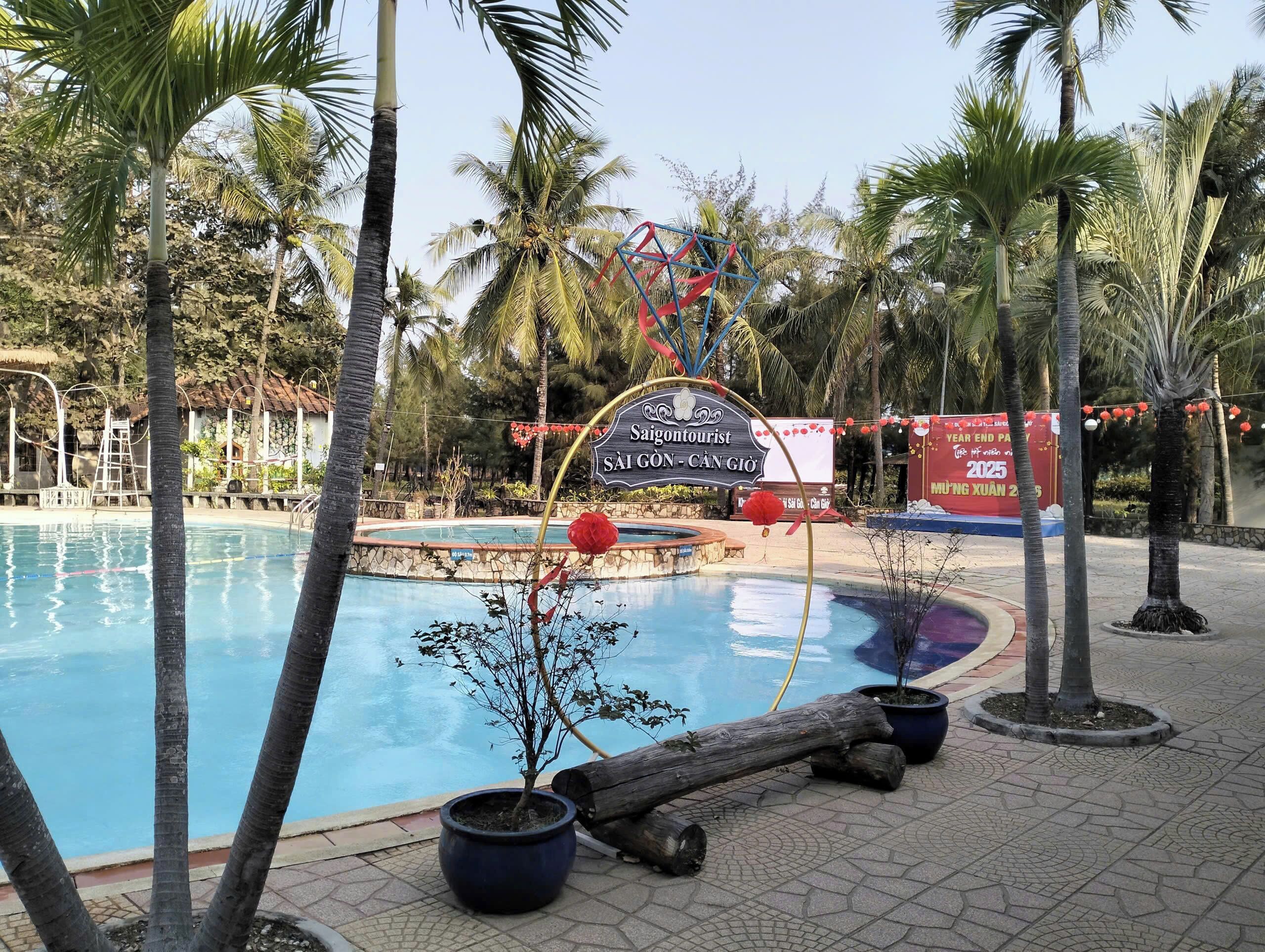 A swimming pool surrounded by palm trees and a sign indicating a tourist attraction.