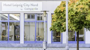 A hotel exterior with large windows and outdoor seating. - Hotel Leipzig City Nord by Campanile (Leipzig)