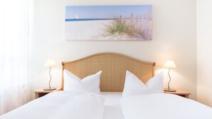 A hotel room with a bed, two bedside lamps, a headboard, and a beach-themed wall art. - Hotel Leipzig City Nord by Campanile (Leipzig)