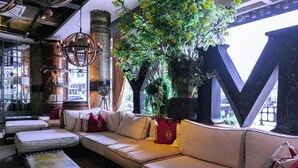 A modern interior with a large white sofa, a wooden coffee table, and a large letter 'M' structure. - M Boutique Hotel (Ipoh)