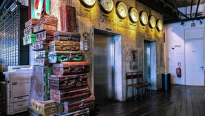 A lobby with a stack of vintage suitcases, a fire extinguisher, and a wall clock. - M Boutique Hotel (Ipoh)